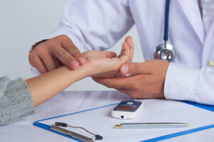 A Medical Doctor holding a patient's hand to check for diabetes